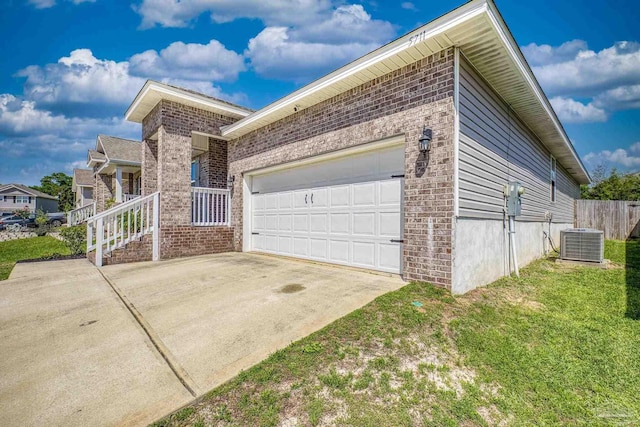5711 Guinevere Ln, Milton, FL 32583 - view of home's exterior with a lawn, a garage, cooling unit, concrete driveway, and brick siding