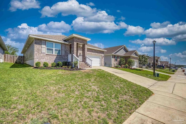 5711 Guinevere Ln, Milton, FL 32583 - view of front facade with concrete driveway, a front yard, brick siding, a garage, and fence
