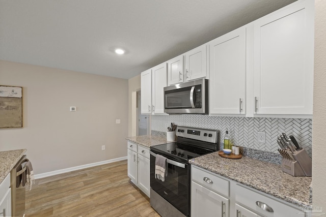 5711 Guinevere Ln, Milton, FL 32583 - kitchen with tasteful backsplash, light wood-style flooring, appliances with stainless steel finishes, and white cabinets