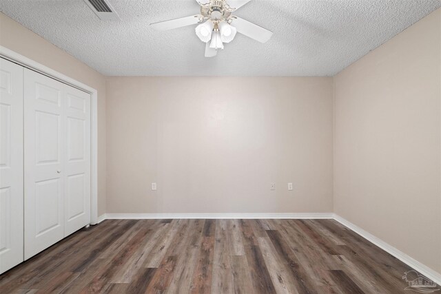 unfurnished bedroom with dark hardwood / wood-style flooring, ceiling fan, a closet, and a textured ceiling