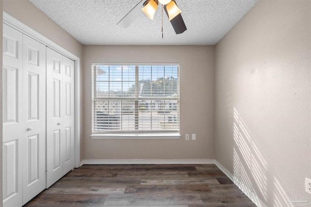 unfurnished bedroom with dark hardwood / wood-style flooring, ceiling fan, a closet, and a textured ceiling