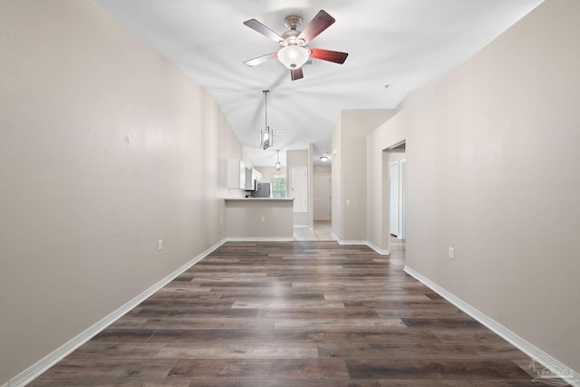 unfurnished living room featuring lofted ceiling, dark hardwood / wood-style floors, and ceiling fan