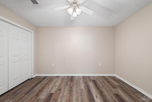 unfurnished bedroom featuring dark hardwood / wood-style flooring, ceiling fan, a closet, and a textured ceiling