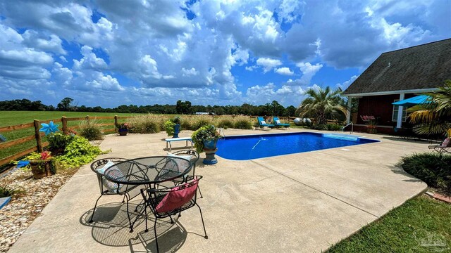 view of pool featuring a rural view and a patio area