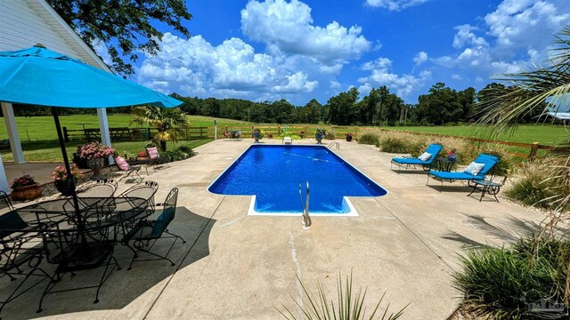 view of pool with a lawn and a patio area