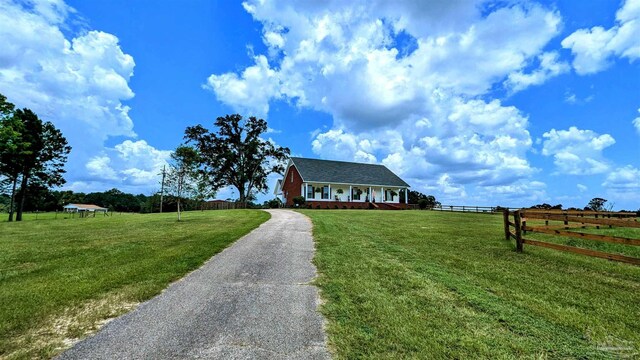 view of front facade with a rural view and a front yard