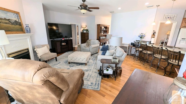 living room featuring light hardwood / wood-style floors, sink, and ceiling fan