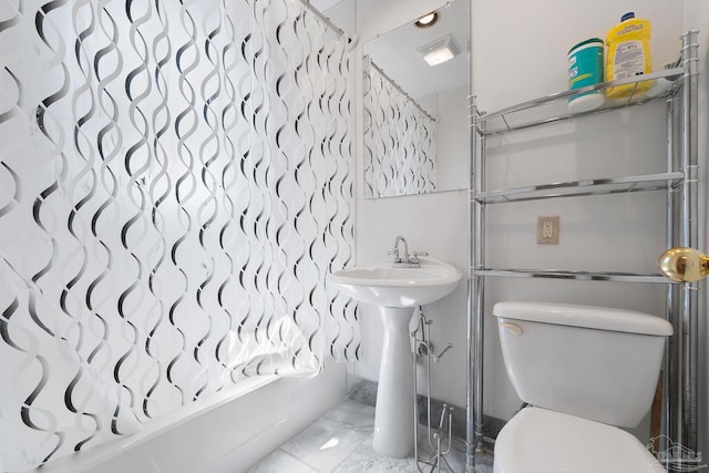 bathroom featuring marble finish floor, toilet, shower / bath combo, and visible vents