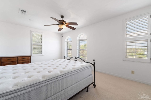 carpeted bedroom featuring a ceiling fan, baseboards, and visible vents