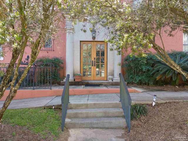 doorway to property featuring french doors and stucco siding