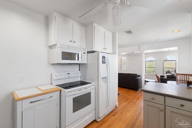 kitchen featuring open floor plan, white appliances, light wood-style floors, visible vents, and ceiling fan