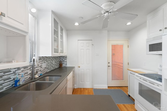 kitchen with white cabinets, a sink, light wood-style flooring, and white appliances