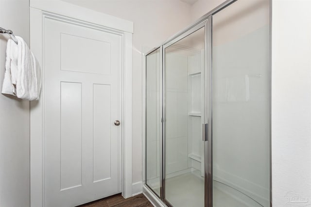 bathroom featuring hardwood / wood-style floors and a shower with door