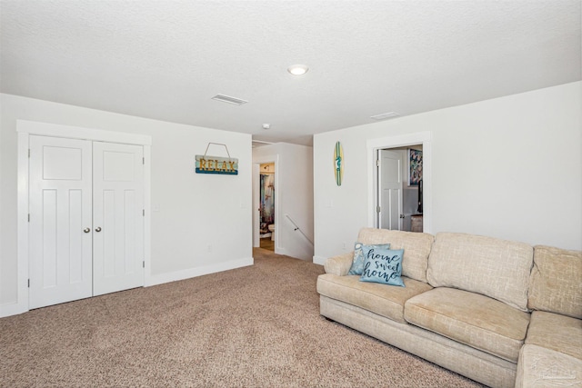 living room featuring a textured ceiling and carpet