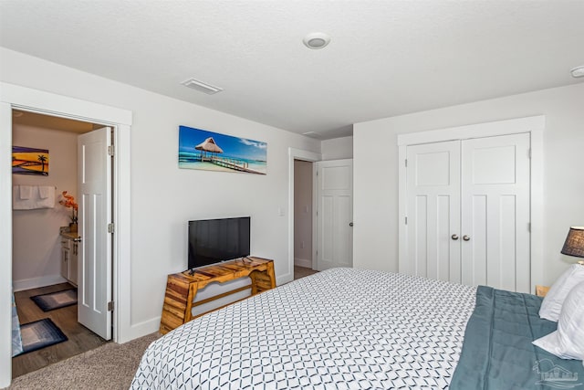 bedroom featuring a textured ceiling, a closet, and dark hardwood / wood-style floors