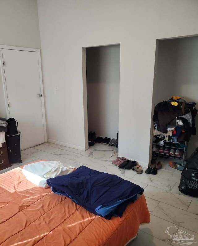 bedroom featuring baseboards and marble finish floor