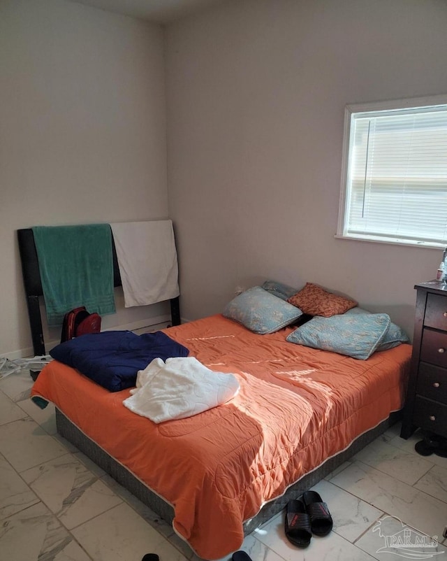 bedroom featuring marble finish floor
