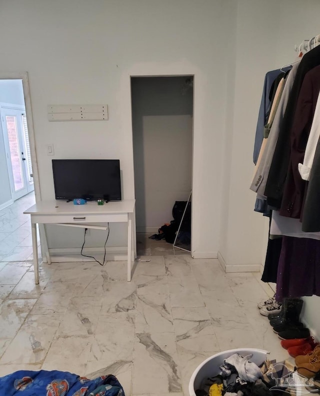 living area featuring marble finish floor and baseboards
