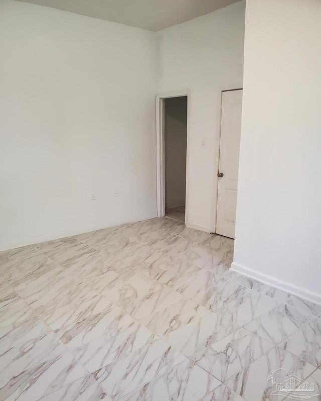 empty room featuring baseboards and marble finish floor