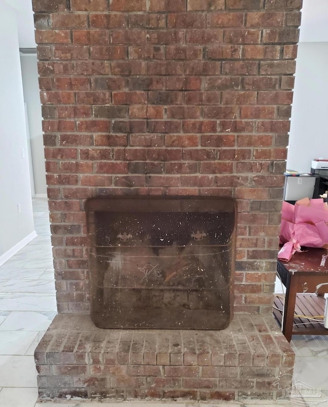 details featuring baseboards and a brick fireplace