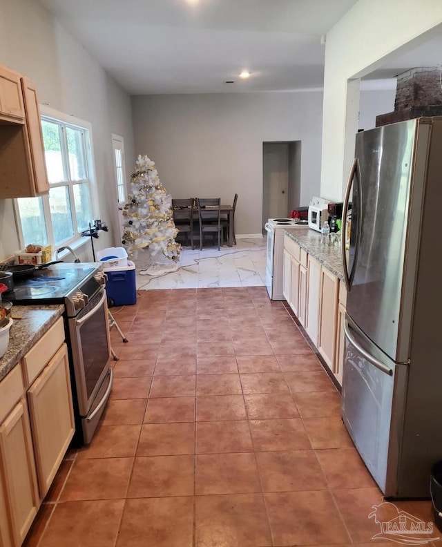 kitchen featuring recessed lighting, appliances with stainless steel finishes, light brown cabinets, light stone counters, and light tile patterned floors