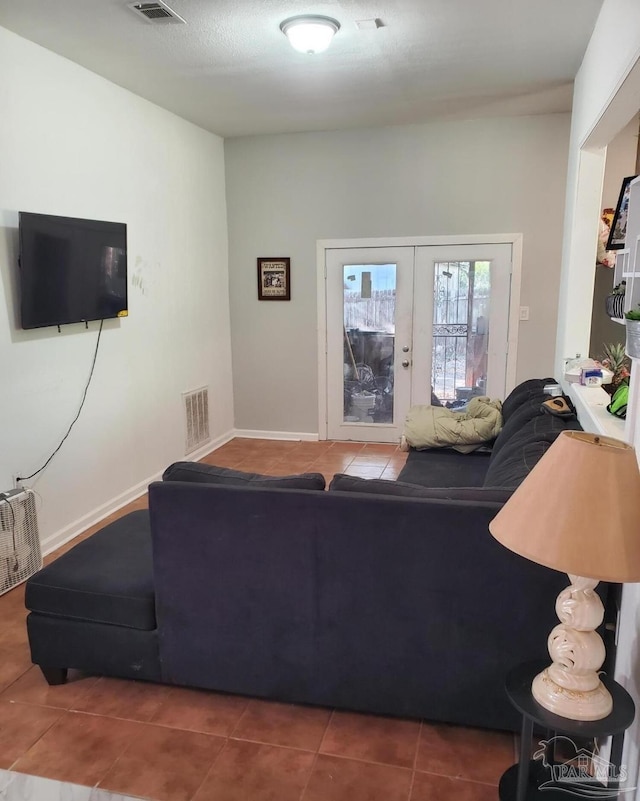 tiled living room with visible vents and french doors
