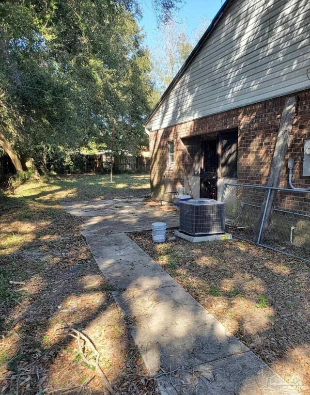 view of yard with central AC unit and fence