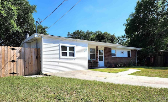 view of front facade featuring a front yard, fence, and brick siding