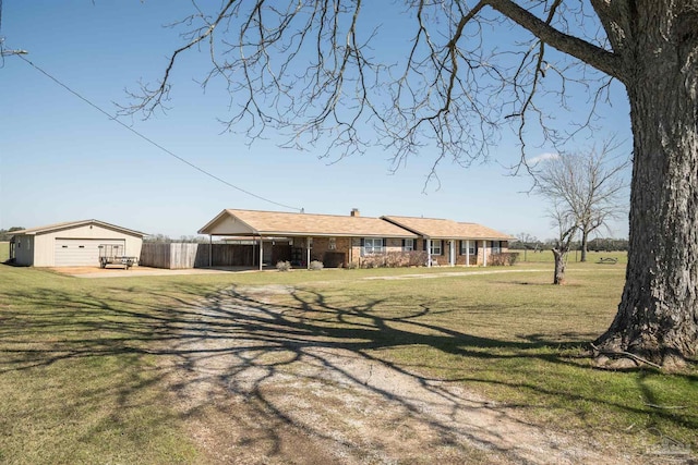 ranch-style home featuring a chimney, fence, a front lawn, and an outbuilding