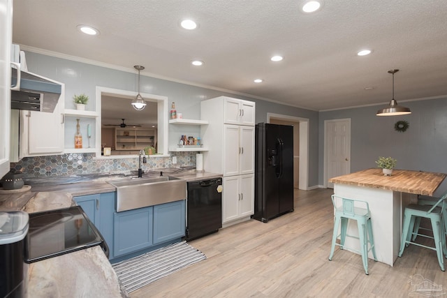 kitchen featuring open shelves, white cabinetry, a sink, black appliances, and a kitchen breakfast bar