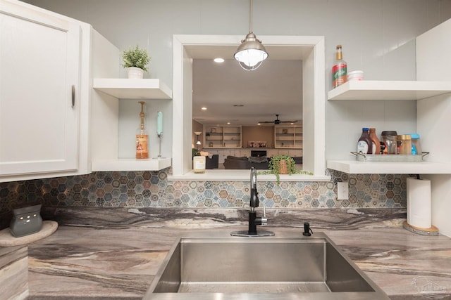 kitchen with tasteful backsplash, ceiling fan, white cabinetry, open shelves, and a sink