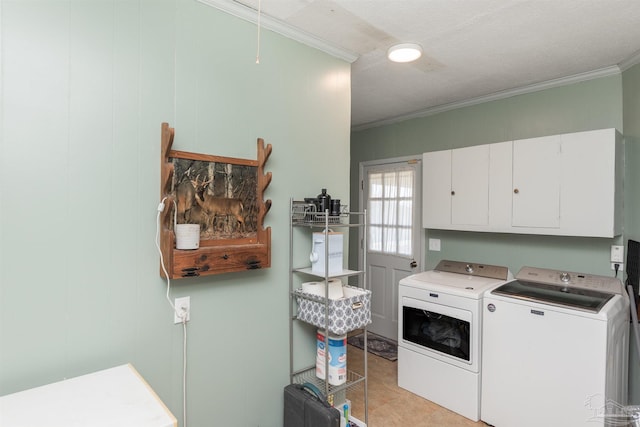 washroom featuring washing machine and dryer, cabinet space, and crown molding