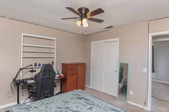 carpeted bedroom featuring baseboards, a closet, visible vents, and a textured ceiling