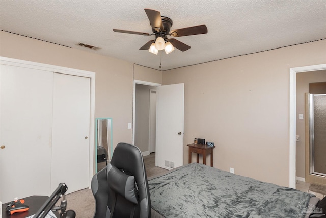 bedroom featuring a ceiling fan, a textured ceiling, visible vents, and a closet