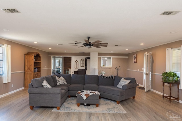 living area with light wood-type flooring, a healthy amount of sunlight, and visible vents