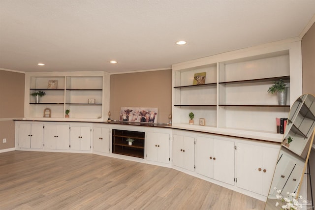 bar featuring light wood-style floors, crown molding, and recessed lighting