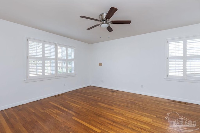 empty room featuring ceiling fan, hardwood / wood-style flooring, and a healthy amount of sunlight