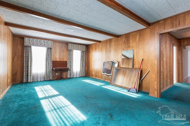 interior space featuring carpet, wooden walls, and beam ceiling