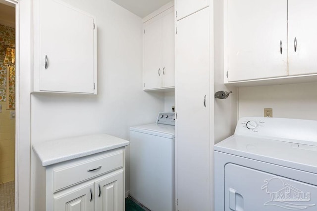 washroom with washing machine and dryer and cabinets