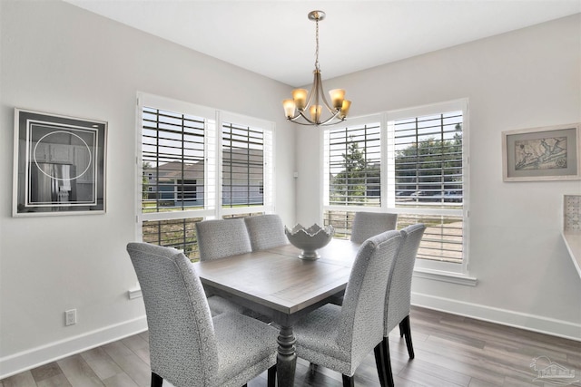 dining room with dark hardwood / wood-style flooring and an inviting chandelier