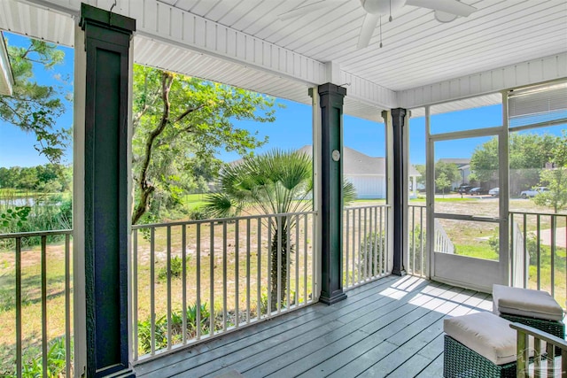 unfurnished sunroom with ceiling fan