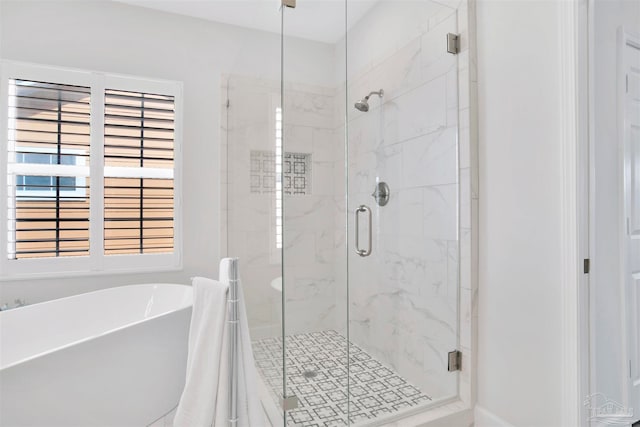 bathroom featuring independent shower and bath and a wealth of natural light