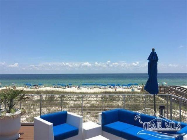 view of patio featuring a water view, a balcony, a beach view, and an outdoor hangout area