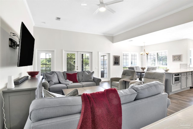 living room with ceiling fan with notable chandelier, ornamental molding, french doors, and light wood-type flooring