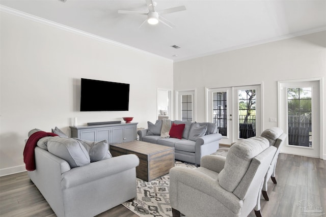 living room with wood-type flooring, ornamental molding, ceiling fan, and french doors