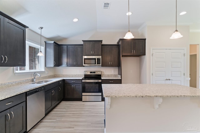 kitchen with light wood-style flooring, a sink, stainless steel appliances, visible vents, and ornamental molding