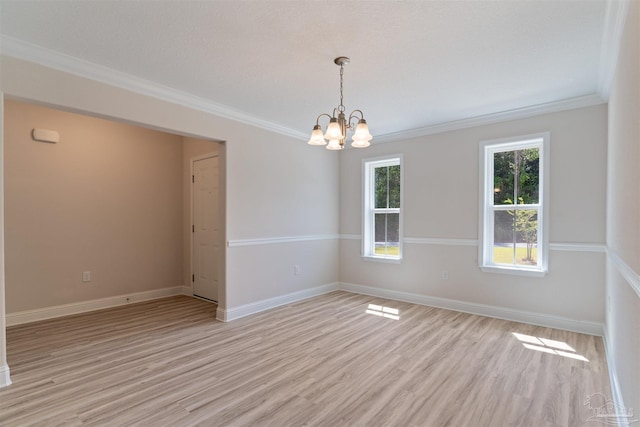 unfurnished room featuring crown molding, light wood-type flooring, and a chandelier
