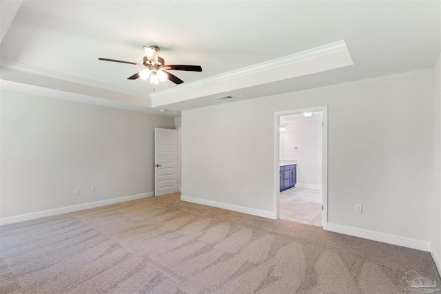 unfurnished room with crown molding, visible vents, a raised ceiling, ceiling fan, and light carpet