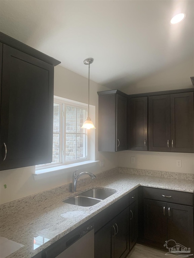 kitchen featuring pendant lighting, sink, light stone counters, and dishwasher