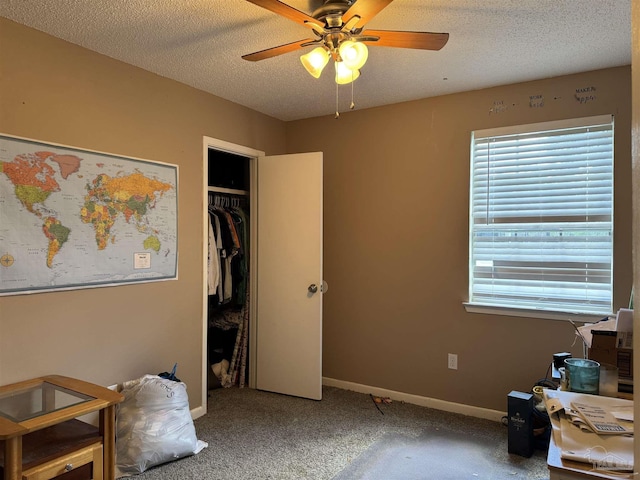 carpeted bedroom featuring multiple windows, baseboards, a textured ceiling, a closet, and a ceiling fan